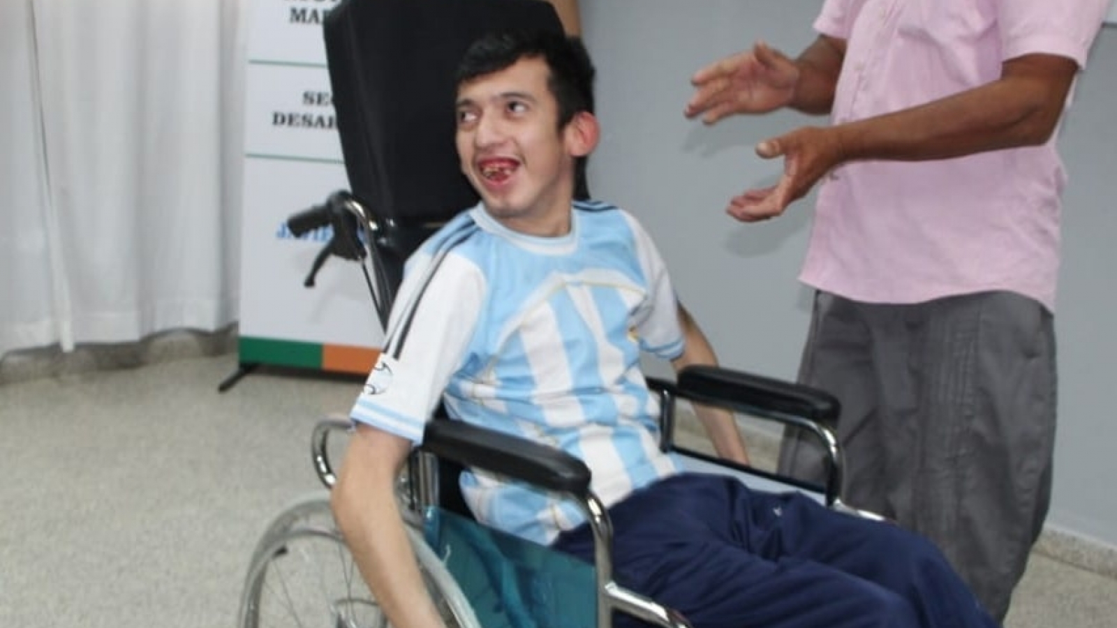 Persona con su nueva silla de ruedas sonriendo y movilizándose