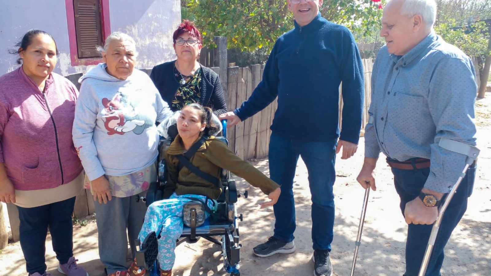 Personas mostrando la nueva silla de ruedas postural entregada a niño